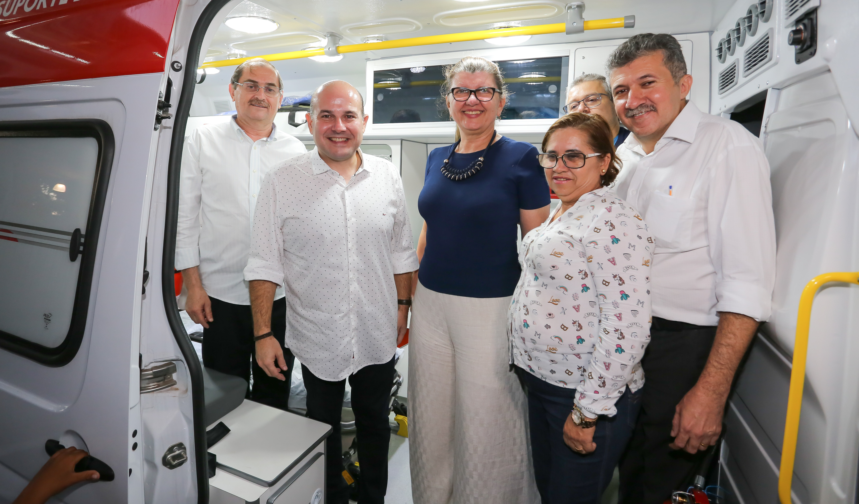 um grupo de pessoas posa para a foto dentro de uma ambulância que foi entregue na base descentralizada do samu